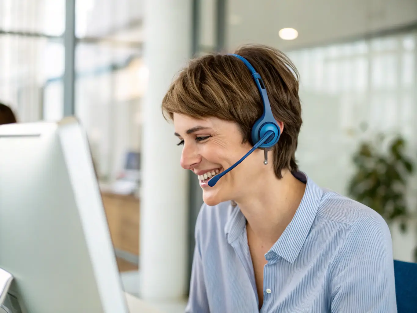 A friendly customer support agent is assisting a tenant over a video call, with a bright and welcoming office environment in the background. The scene emphasizes helpfulness and accessibility.